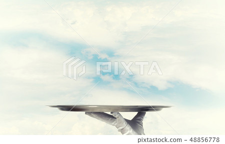 Waiter holding empty silver platter ready for product or item placement 48856778