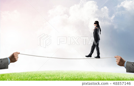 Business concept of risk support and assistance with man balancing on rope Business concept of risk support and assistance with man balancing on rope 48857146