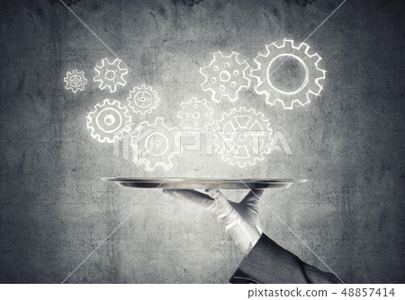Waiter hand with empty silver tray and drawn gears concept 48857414