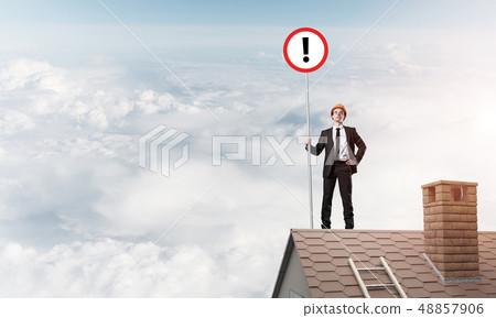 Businessman on house top showing sign with exclamation mark. Mix Businessman on house top showing sign with exclamation mark. Mix 48857906