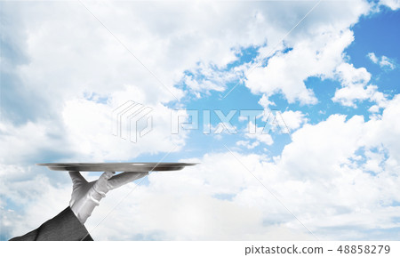 Waiter holding empty silver platter ready for product or item placement Waiter holding empty silver platter ready for product or item placement 48858279