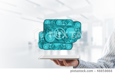 Close of businessman holding tablet pc with engine presenting teamwork and cooperation 48858668