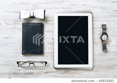 Gentleman kit of tablet watch glasses bow tie and notebook on wooden table Gentleman kit of tablet watch glasses bow tie and notebook on wooden table 48858892