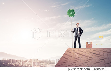 Businessman in suit on house top with ecology concept signboard. 48859468
