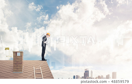 Engineer man standing on roof and looking down. Mixed media 48859579