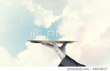 Waiter holding empty silver platter ready for product or item placement Waiter holding empty silver platter ready for product or item placement 48859627