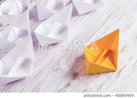 Business leadership concept with white and color paper boats on 48860409