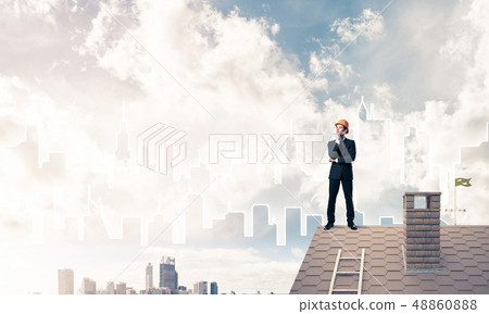Engineer man standing on roof and looking away. Mixed media 48860888