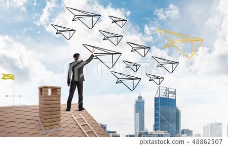 Businessman standing with back on house brick roof and drawing. Mixed media 48862507