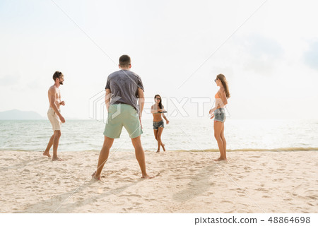 Group of friends playing at the beach on summer 48864698