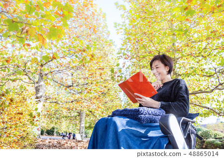 女人最新的電動輪椅走沿著大道的鳳梨 48865014