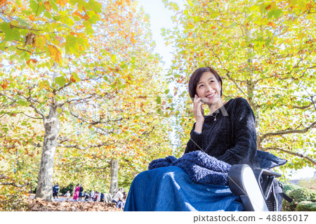 A woman walking on a phone with the latest electric wheelchair A woman walking on a phone with the latest electric wheelchair 48865017