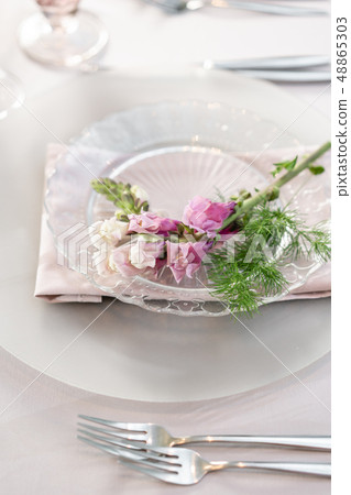 Closeup Table setting with plates and tableware, adorned with flowers. Floral decoration for wedding Closeup Table setting with plates and tableware, adorned with flowers. Floral decoration for wedding 48865303