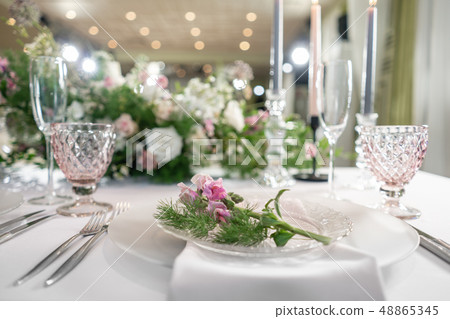 Closeup Table setting with plates and tableware, adorned with flowers. Floral decoration for wedding Closeup Table setting with plates and tableware, adorned with flowers. Floral decoration for wedding 48865345