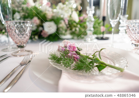 Closeup Table setting with plates and tableware, adorned with flowers. Floral decoration for wedding Closeup Table setting with plates and tableware, adorned with flowers. Floral decoration for wedding 48865346