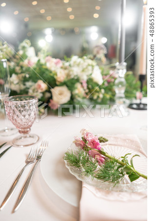 Closeup Table setting with plates and tableware, adorned with flowers. Floral decoration for wedding Closeup Table setting with plates and tableware, adorned with flowers. Floral decoration for wedding 48865393