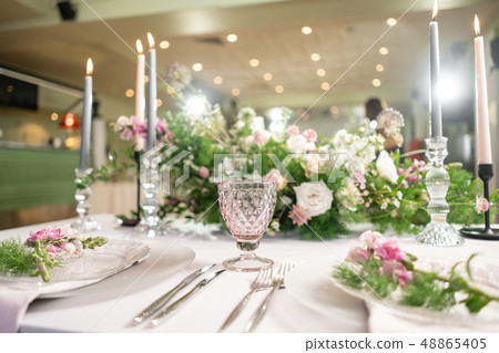 Closeup Table setting with plates and tableware, adorned with flowers. Floral decoration for wedding Closeup Table setting with plates and tableware, adorned with flowers. Floral decoration for wedding 48865405