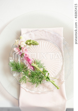 Closeup Table setting with plates and tableware, adorned with flowers. Floral decoration for wedding Closeup Table setting with plates and tableware, adorned with flowers. Floral decoration for wedding 48865415