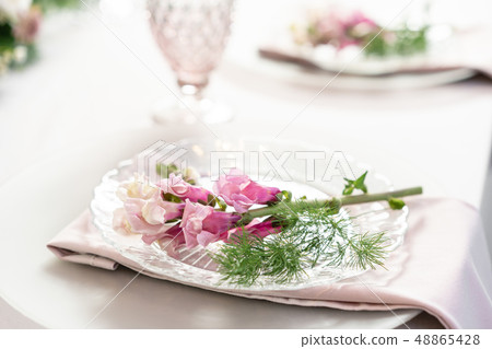 Closeup Table setting with plates and tableware, adorned with flowers. Floral decoration for wedding Closeup Table setting with plates and tableware, adorned with flowers. Floral decoration for wedding 48865428