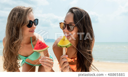Happy beautiful woman friends at the beach in 48865881