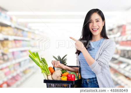 Asian woman with shopping basket full of groceries Asian woman with shopping basket full of groceries 48868049