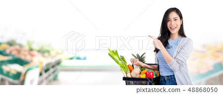 Woman with shopping basket full of groceries in Woman with shopping basket full of groceries in 48868050