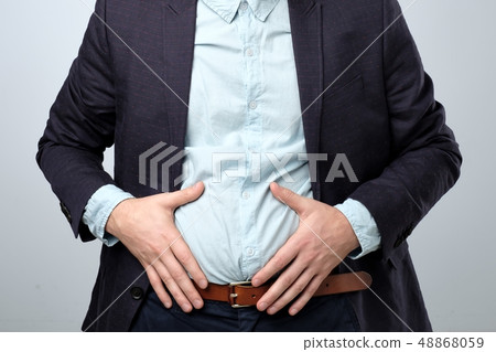 Stomach pain. man in suit holding his stomach 48868059