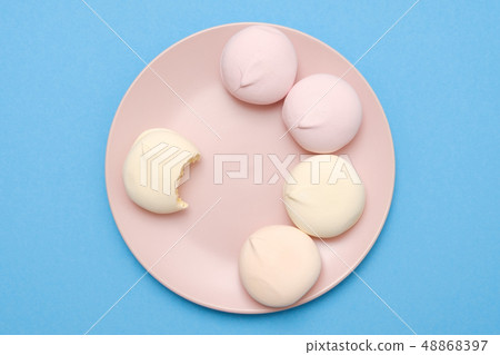 Tasty and sweet circle marshmallows on plate on blue background with copyspace. 48868397