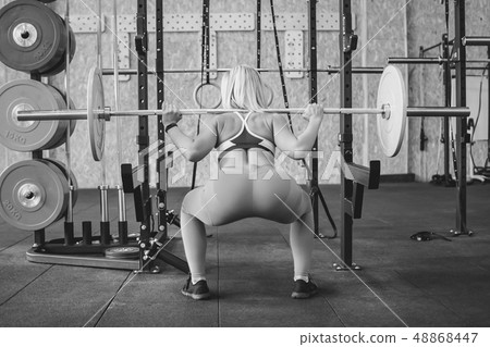 girl squats with a barbell 48868447