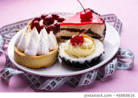 pink background with delicious cakes and measure tape 48868616