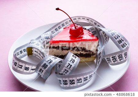 pink background with delicious cakes and measure tape 48868618