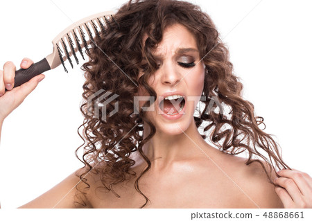 Beautiful brunette girl with a perfectly curly hair with a hairbrush, and classic make-up. Beauty 48868661
