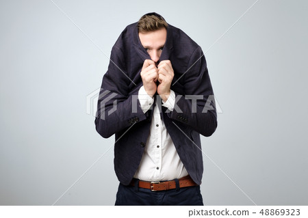 Young man in too big suit. He is offended and looking stressed. Young man in too big suit. He is offended and looking stressed. 48869323