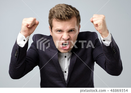 Anger crazy handsome man in suit standing shouting or screaming Anger crazy handsome man in suit standing shouting or screaming 48869354