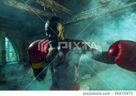 Hand of boxer over black background. Strength, attack and motion concept 48870973