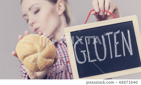 Woman holding board with gluten sign and bun bread 48871640