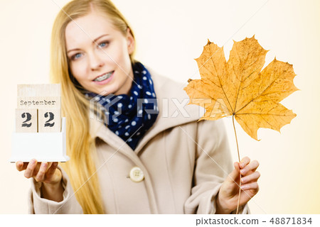 Woman holding calendar with first autumn day 48871834
