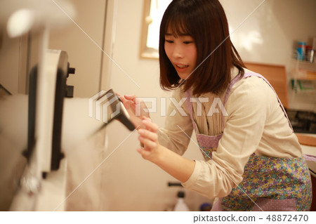 A woman who is troubled by the oven toaster 48872470