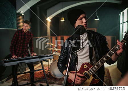 Music band having rehearsal in a studio 48873715