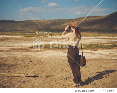 Beautiful woman with binoculars at savanna in Kenya 48874362