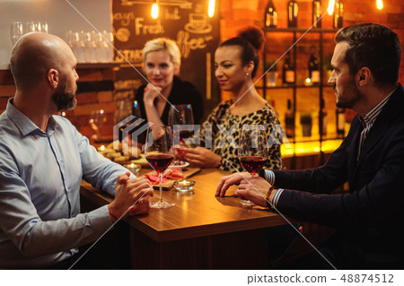 Group of friends having fun talk behind bar counter in a cafe Group of friends having fun talk behind bar counter in a cafe 48874512