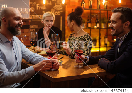 Group of friends having fun talk behind bar counter in a cafe Group of friends having fun talk behind bar counter in a cafe 48874514