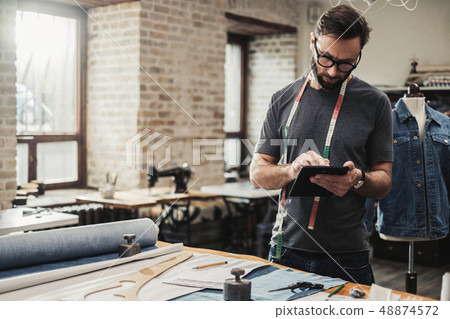Fashion designer working in his studio Fashion designer working in his studio 48874572