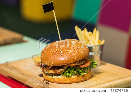 fresh tasty beef burger with cheese and french fries on wood background 48874716