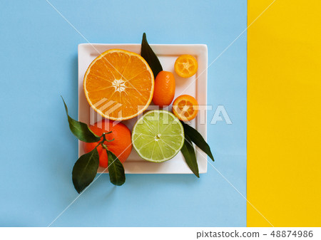 Citrus fruits on a blue and yellow background Citrus fruits on a blue and yellow background 48874986