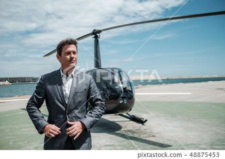 Businessman standing near private helicopter 48875453