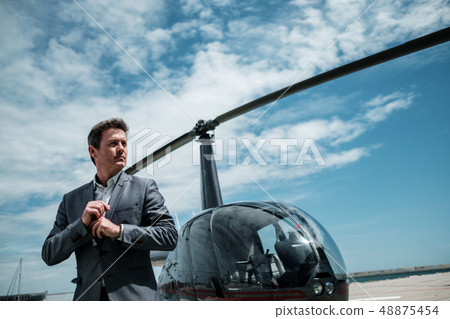 Businessman standing near private helicopter 48875454