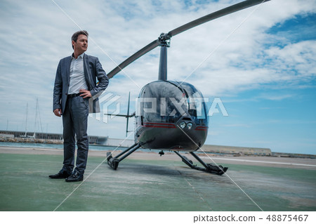 Businessman standing near private helicopter 48875467