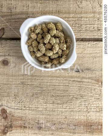 dried mulberry fruits on a wooden table 48876280