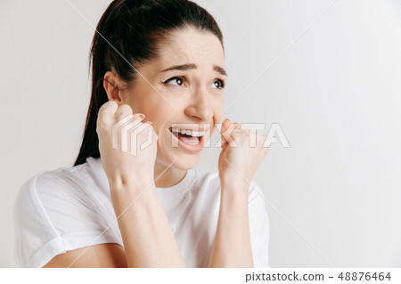 Beautiful woman looking suprised and bewildered isolated on gray Beautiful woman looking suprised and bewildered isolated on gray 48876464